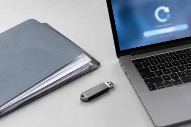 Флешка USB, внешний накопитель и ноутбук на светло-сером фоне без людей и текста